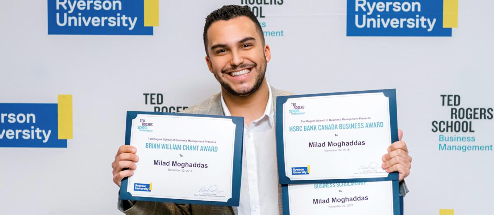 Milad Moghaddas holding three certificates