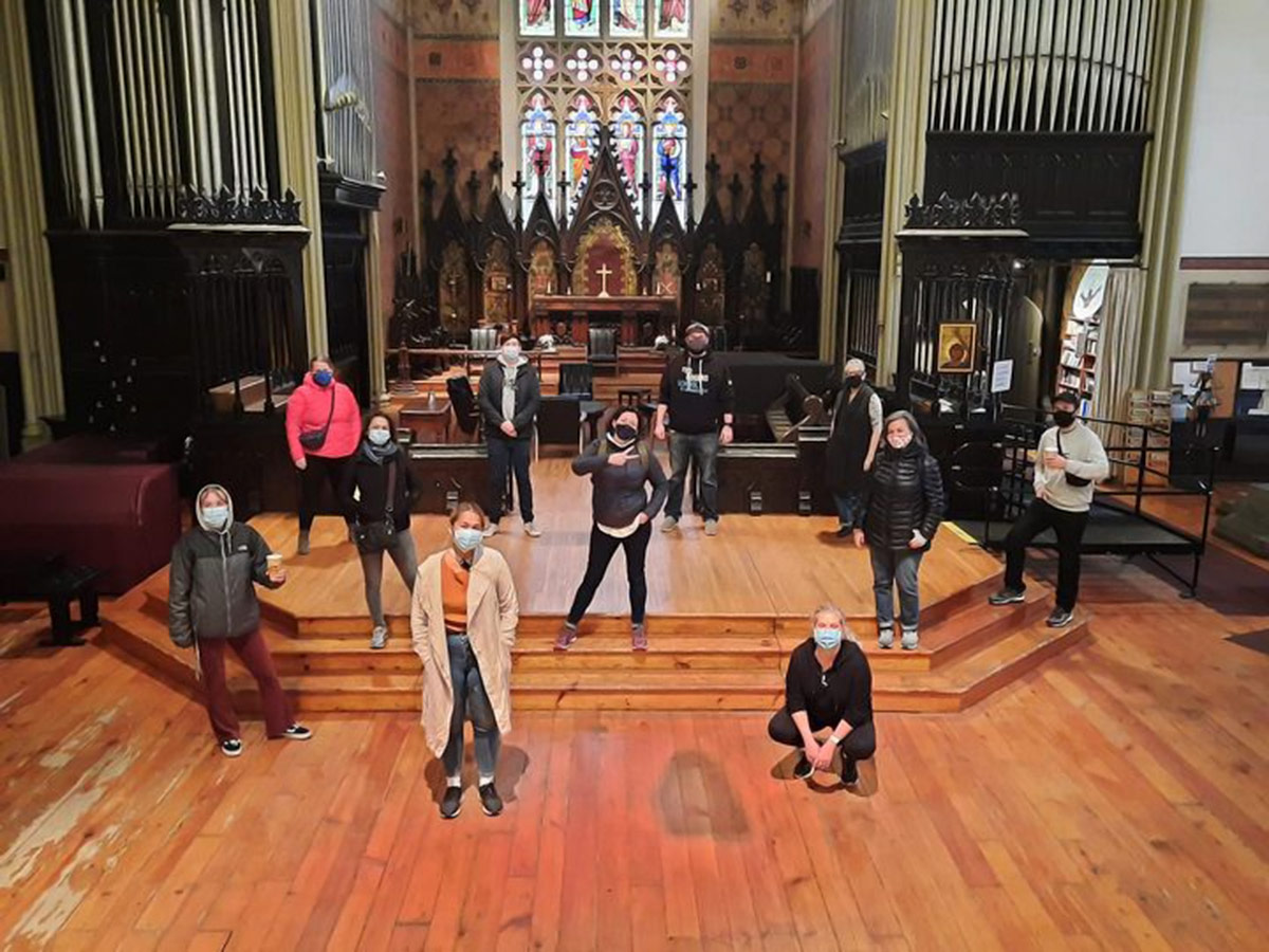 Group of volunteers standing in front of a church sanctuary